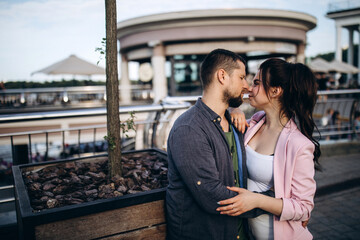 Evening walk of a beautiful young couple around the city. A loving couple travels.