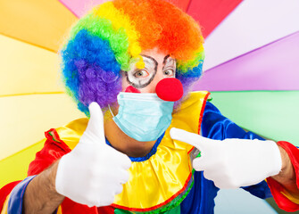 Masked clown giving thumbs up, covid coronavirus concept