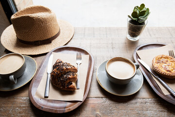 Cups of coffee, fresh croissant and local dessert on a table in a cafe. Travel, vacations, local food, lifestyle, summer fun, enjoy life concept