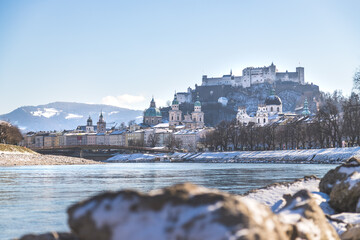 Obraz premium City of Salzburg and snow river bank of Salzach, winter time.