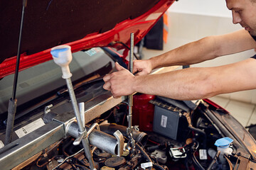 Repairing a car engine in auto-service center. Auto mechanic working in the garage