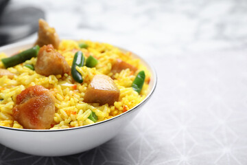 Delicious rice pilaf with meat served on table, closeup. Space for text