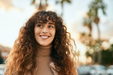 Young hispanic woman smiling happy standing at the city