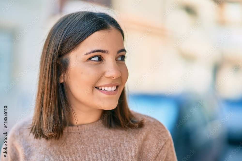 Wall mural young hispanic woman smiling happy standing at the city.