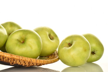 Several sweet green apples by Renet Simirenko with a ceramic plate, close-up, isolated on white.