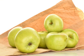 Several sweet green apples by Renet Simirenko on brown paper, close-up, isolated on white.
