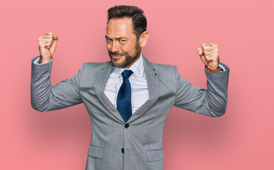Middle age man wearing business clothes showing arms muscles smiling proud. fitness concept.