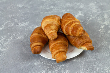 Fresh French croissants on gray stone table