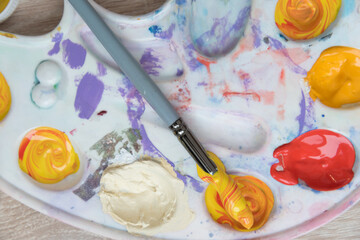 Artist's palette, top view. Mixing paints, brush. Texture, background