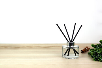 luxury aroma scent reed diffuser glass bottle is on the wooden table to creat romantic and relax ambient in the bedroom with white cement wall background in the morning for happy valentine day