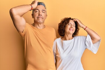 Beautiful middle age couple together wearing casual clothes smiling confident touching hair with hand up gesture, posing attractive and fashionable