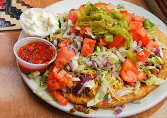 large Navajo taco on a plate with sauces