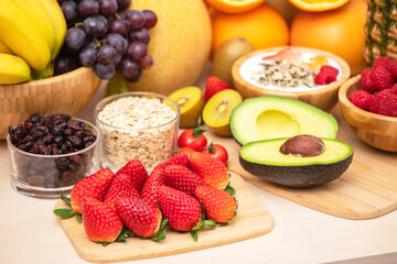 Group Fruits mixed with banana, orange, strawberry and nuts, concept health food and diet, vegetarian food in the top view on the wood table.