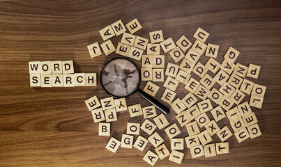 English alphabet letters in random order and magnifier on wooden background. Search letters and words concept.