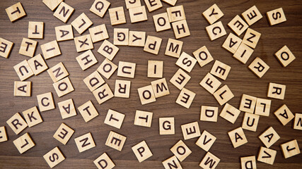 English alphabet letters in random order on wooden background. Search letters and words concept.