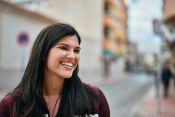 Young hispanic girl smiling happy standing at the city.
