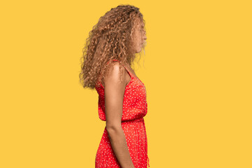 Beautiful caucasian teenager girl wearing summer dress looking to side, relax profile pose with...
