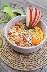 Healthy food smoothie bowl Fresh fruit smoothie is good for the body. with mango, banana, nuts, seeds, papaya, almonds, sunflower and  granola and apple for healthy ingredients placed on the table.