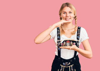 Young beautiful blonde woman wearing oktoberfest dress gesturing with hands showing big and large...