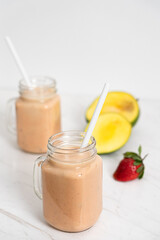 Obraz na płótnie Canvas Summer Fruits Milkshake with Mango, Banana and Strawberries