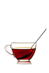 Transparent glass cup with tea and teaspoon. Isolated on a white background
