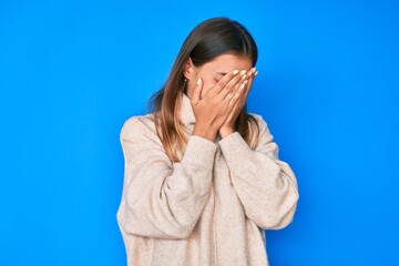 Beautiful caucasian woman wearing wool winter sweater with sad expression covering face with hands while crying. depression concept.