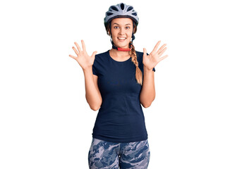 Beautiful caucasian woman wearing bike helmet showing and pointing up with fingers number ten while smiling confident and happy.
