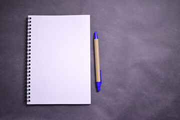 white notebook with eco-friendly pen and space for text on black textured background