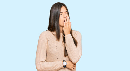 Young brunette woman wearing casual winter sweater bored yawning tired covering mouth with hand. restless and sleepiness.