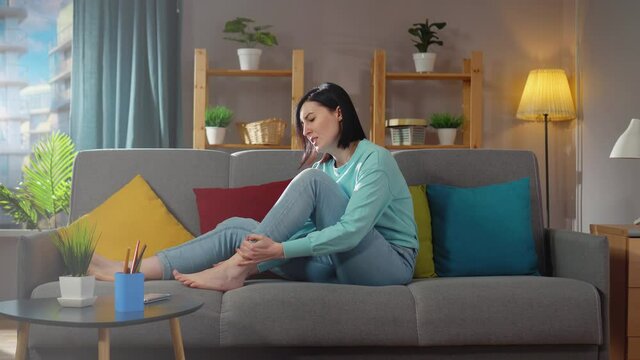 young woman sitting has pain in her leg