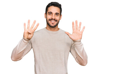 Young hispanic man wearing casual clothes showing and pointing up with fingers number nine while...