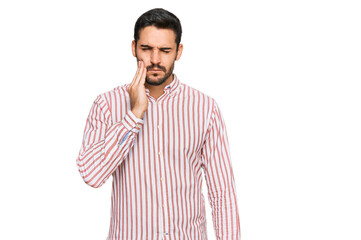 Fototapeta premium Young hispanic man wearing business shirt touching mouth with hand with painful expression because of toothache or dental illness on teeth. dentist