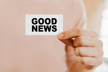 Man holding a business card with Good News