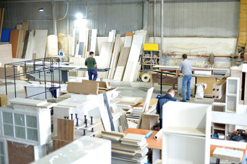 Background image of carpenters workshop: production equipment, various woodworking tools, wooden boards and parts of furniture in factory. Concept of own small successful production.