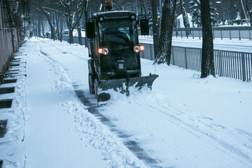 Snowplow removing snow on street after blizzard. Snowplow vehicle clears snowy road during...