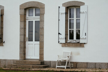 Fototapeta na wymiar door window and white chair on typical building of Brittany, France