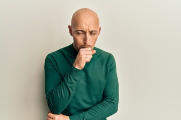 Bald man with beard wearing casual turtleneck sweater feeling unwell and coughing as symptom for cold or bronchitis. health care concept.