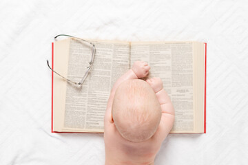 a baby with a book, a top view, the concept of training and development