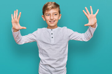 Little caucasian boy kid wearing casual clothes showing and pointing up with fingers number ten while smiling confident and happy.