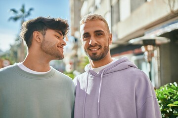 Young gay couple smiling happy and hugging at the city.