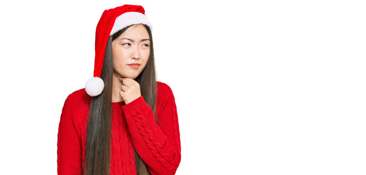 Young chinese woman wearing christmas hat touching painful neck, sore throat for flu, clod and infection