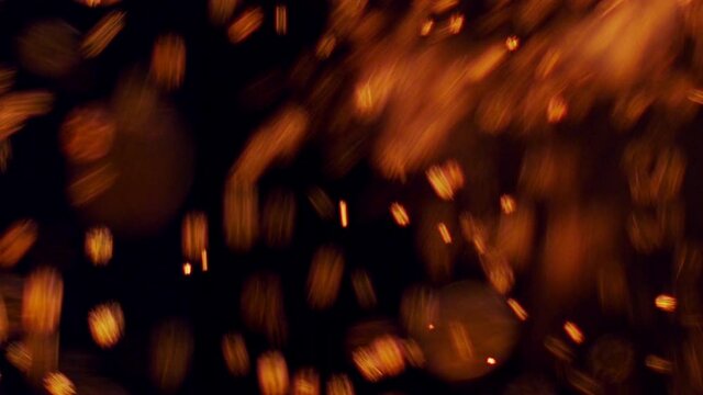 Sparks from the fire swirl on a black background
