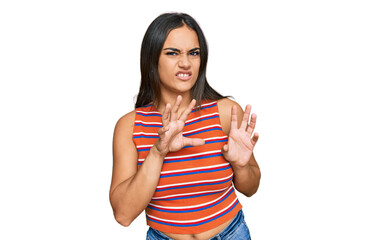 Young brunette woman wearing casual clothes disgusted expression, displeased and fearful doing disgust face because aversion reaction. with hands raised