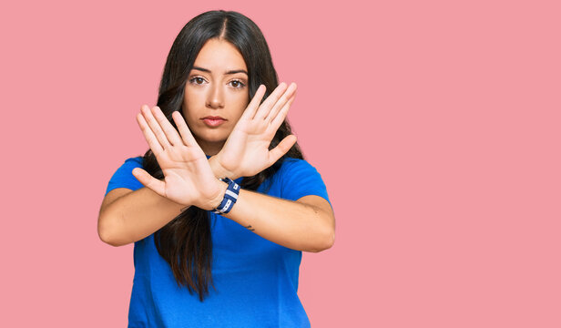 Beautiful brunette young woman wearing casual clothes rejection expression crossing arms doing negative sign, angry face