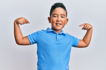 Little boy hispanic kid wearing casual clothes looking confident with smile on face, pointing...