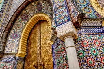 Fotobehang Marokko Ingewikkelde tegelpatronen, metaalwerk en gipsgravures die de buitenkant van gebouwen in Fez, Marokko sieren