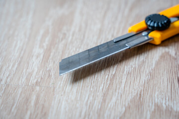 Extreme Close up of Construction Knife on Wooden Background, Close up with Selective Focus and Copy...