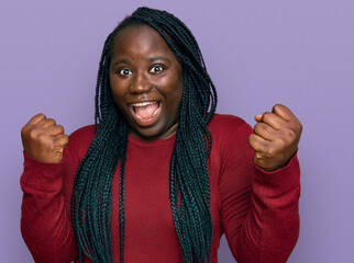 Young black woman with braids wearing casual clothes screaming proud, celebrating victory and success very excited with raised arms