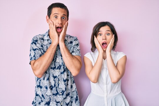 Beautiful couple wearing casual clothes afraid and shocked, surprise and amazed expression with hands on face