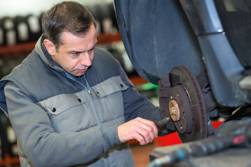 mechanic hands with tool changing tyre of car
